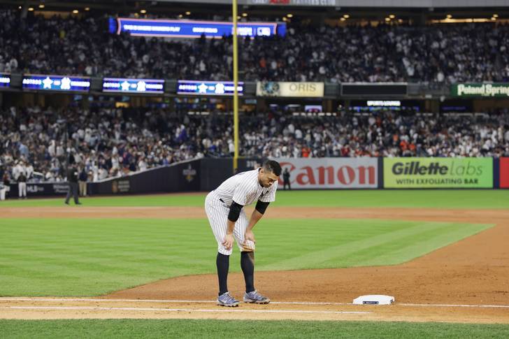 New York Yankees baserunner Giancarlo Stanton waits for his glove after being stranded on second base against the Houston Astros in the bottom of the fourth inning of the third game of the American League Championship Series at Yankee Stadium.